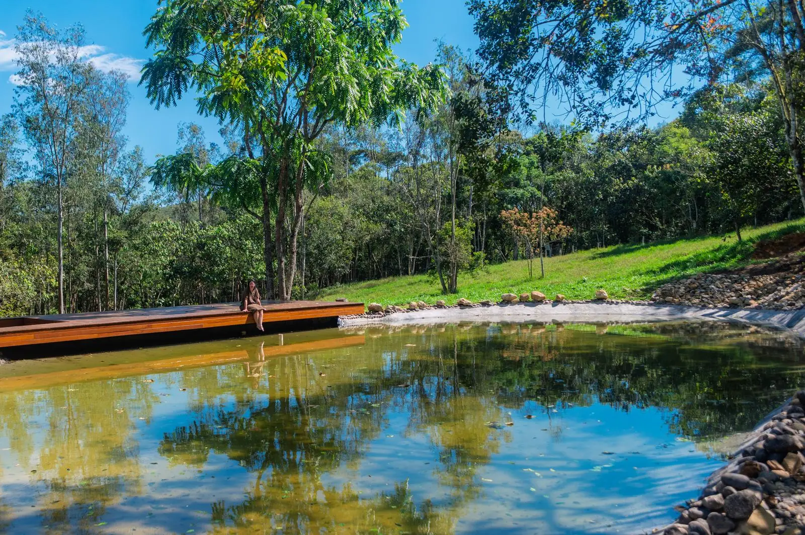 O lago com o deck de madeira, cercado pela mata
