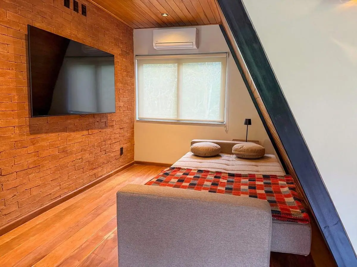 A mesma sala com o sofá aberto em cama